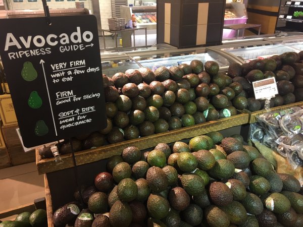 Avocado display with ripeness guide in a supermarket Avocados