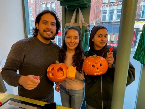 Co-workers having fun carving pumpkins at their work place Carved pumpkin