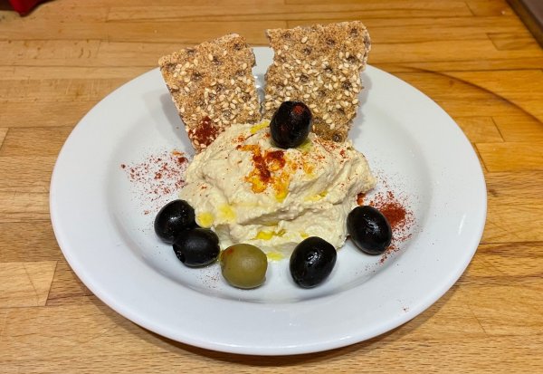 Homemade hummus with some green and black olives topped with extra virgin olive oil Hummus