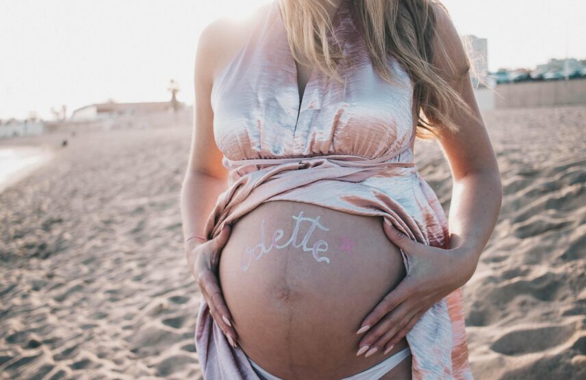 A woman gently showcases her baby bump, embracing the journey of motherhood. A woman gently showcases her baby bump, embracing the journey of motherhood.