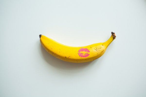 A yellow banana with a bold pink lipstick mark Banana